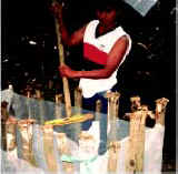 Photo of a man stirring the solution in a small plastic-lined pit