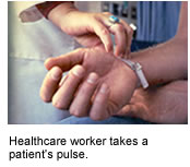 Health-care worker takes pulse of early NIH AIDS patient.
